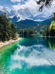 Beautiful green turquoise lake in the mountains with snow peaks, clouds in the sky 