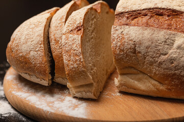 Cut fresh bread on the table, slices of bread on a wooden board