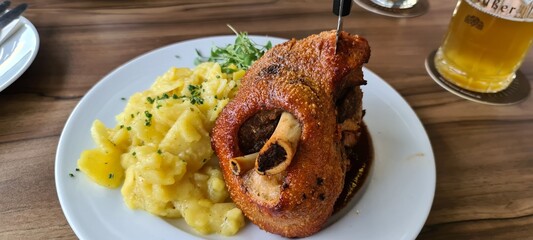 Traditional and crispy roasted pork knuckle with potato salad in Reutlingen