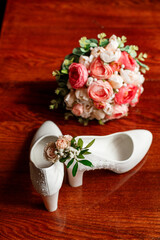 Bridal accessories. White shoes, bridal bouquet, boutonniere