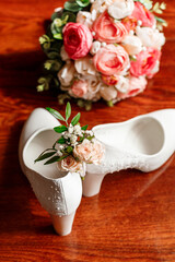 Bridal accessories. White shoes, bridal bouquet, boutonniere