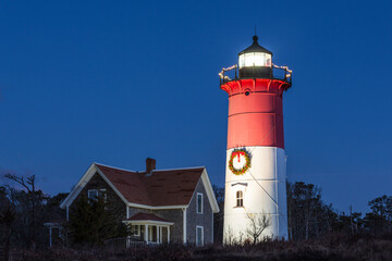 Fototapeta na wymiar USA, Massachusetts, Cape Cod, Eastham. Nauset Light with Christmas wreath at dawn.