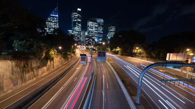 Time Lapse Lockdown: Light Trails On Highway Against Skyscrapers