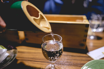 Traditional bamboo bottle serving sake in a glass cup, Japan