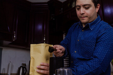 Portrait of a man holding a spoon with many coffee beans.
