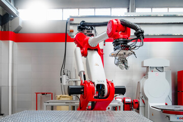Red and white automatic welding robot in factory
