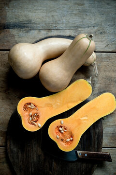 Butternut pumpkins (Cucurbita moschata) cut in halves against rustic background