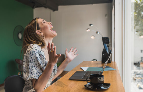 Businesswoman laughing while working at table in cafe