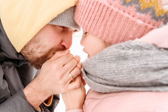 Close-up of father warming daughter's hands during winter