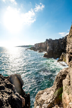 Sea waves crashing against cliffswith cave