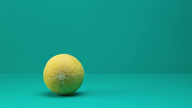 fresh ripe melon rolling and jumping on turquoise background. rotating plate of melon slices. stop motion animation