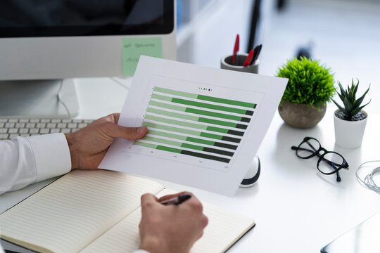 Businessman with graph paper document working on desk at work place