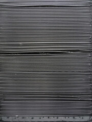 Full frame close-up side view of a segment of stacked large aluminum kitchen food containers