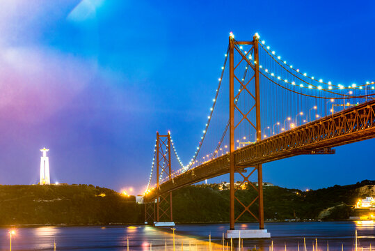 Portugal, Lisbon, Ponte 25 de Abril with Christ the King statue illuminated at night