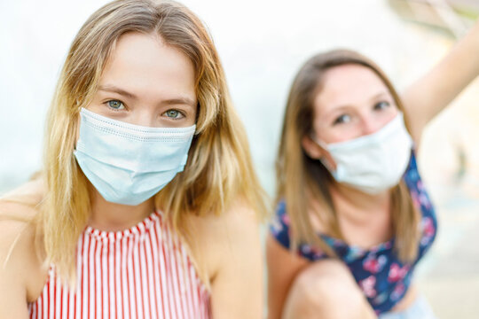 Female friends wearing protective face masks outdoors