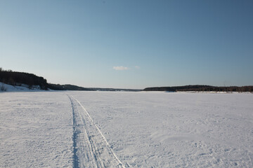 The trail from the snowmobile goes into the distance.
