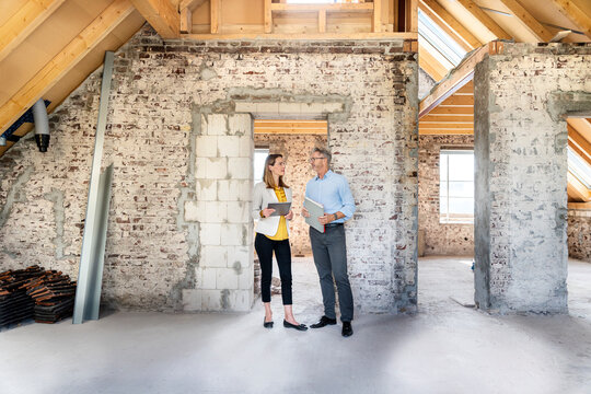 Businesswoman having discussion with expertise while standing at construction site