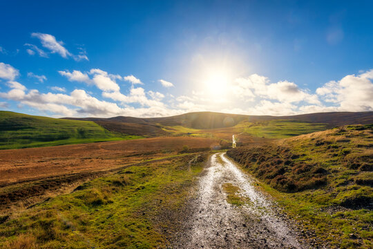 UK, Scotland, East Lothian, Dirt road through hilly landscape