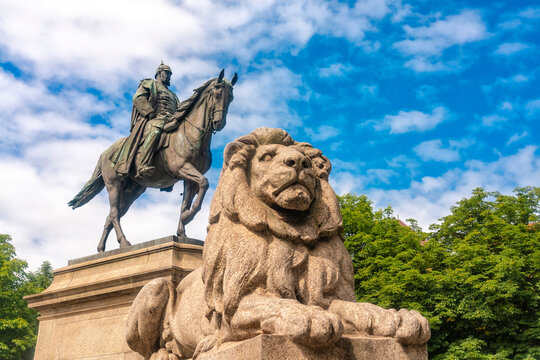 Germany, Baden-Wurttemberg, Stuttgart, Lion resting at foot of equestrian statue of Kaiser Wilhelm I at Karlsplatz