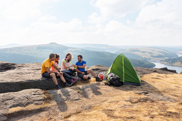 Male and female hiker friends camping on mountain top during vacations