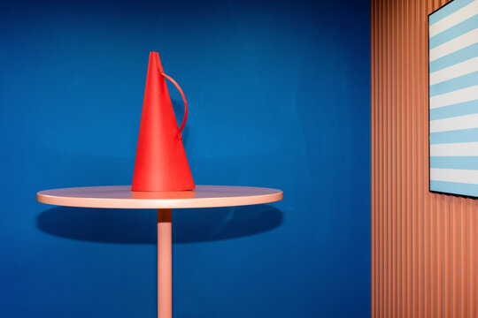 Red megaphone on table against blue wall in office