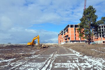 The process of building a multi-storey residential building made of red brick.