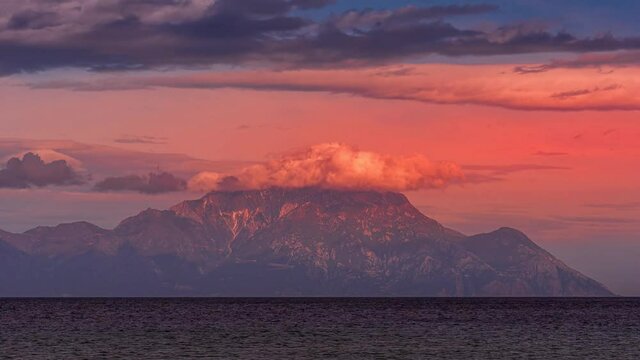4K Time lapse of mountain peak Athos with storm clouds as dramatic volcano red fume during daytime from sunrise to sunset in Greece