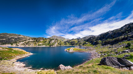 panoramic view of a glacial lake with the mountains in the background, Estany de Sant Maurici, Aigüestortes Park, Lérida, Spain