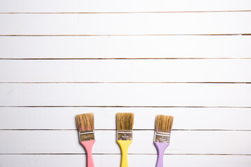 Flowers petals and brushes on a white wood