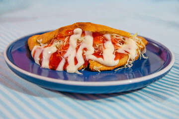 Empanada de masa rellena de carne y ensalada mas aderezos, platillo costarricense