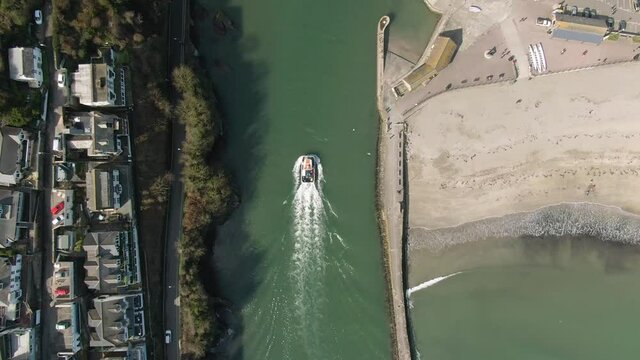 Top down of a fishing boat returning to harbour in the historic seaside cornis town of Looe, UK
