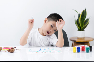 Happy little Asian kid at the table draw with water color Learning and education of kid.