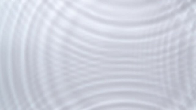 A top view of a drop-down on a white background enters the water and a water circle spreads out. Slow motion video