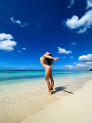 Sexy beautiful caucasian woman posing in white bikini at the sea coast. Exotic country travel and rest concept. Slim figure and sexy body