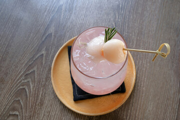 Close-up refreshing  lychee soda in a glass on the wooden table, fruits Italian soda..