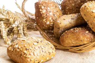 Rye bread. Bakery with crusty loaves and crumbs. Fresh loaf of rustic traditional bread with wheat grain ear or rye spike plant on natural cotton background. Healthy Food concept.