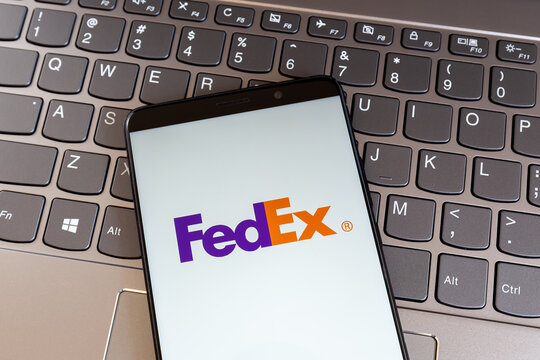 Toronto, On, Canada - March 11, 2021: FedEx logo on smartphone screen on keyboard. FedEx Corporation is an American multinational delivery services company. 