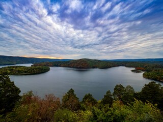 Fototapeta premium Gorgeous view of Raystown Lake from Hawn’s Overlook near Altoona, Pennsylvania in the fall right before sunset with a view of the dramatic blue sky filled with clouds and pops of pink with foliage.