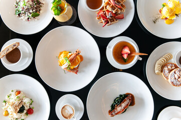 Hotel Breakfast buffet. European style breakfast dishes and coffee on black table top view