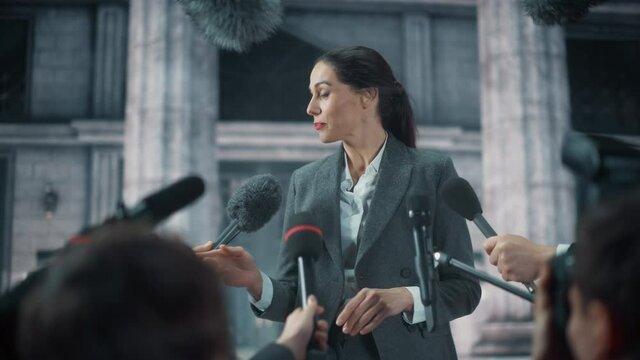 Organization Representative Answering Press Questions and Giving Interview Outside a Parliament, Court or Other Government Building. Press Officer or Businesswoman Crowded by News Journalists. 