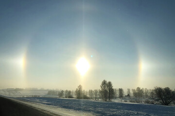 Halo effect over the frozen winter forest, view from the country road. Magical unbelievable nature...