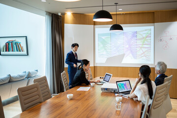 若手男性社員が進行する会議風景