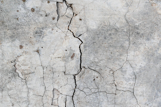 Cracked concrete. Concrete texture with cracks. Gray asphalt.