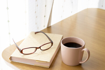 読書の休憩イメージ。本、コーヒー、眼鏡