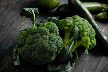 fresh broccoli with zucchini lies on a dark wooden background