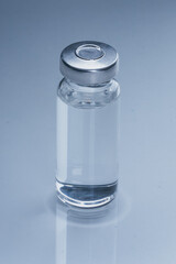 Glass medical ampoule vial for injection. Medicine is dry white drug penicillin powder or liquid with of aqueous solution in ampulla. Close up. Bottles ampule with aluminum cap on backgrounds gray.