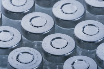 Glass medical ampoule vial for injection. Medicine is dry white drug penicillin powder or liquid with of aqueous solution in ampulla. Close up. Bottles ampule with aluminum cap on backgrounds gray.