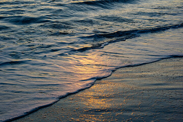 waves in the sand at sunset golden hour