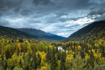 dramatic autumn landscape photo of mountain peaks and calm lakes in the Kenai Peninsula in Alaska .