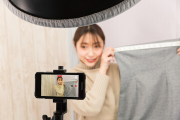 スマートフォンで動画を撮影する女性